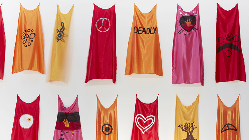 colourful capes hanging on a wall