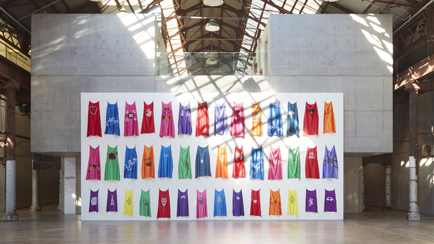 Coloured capes hanging on a wall