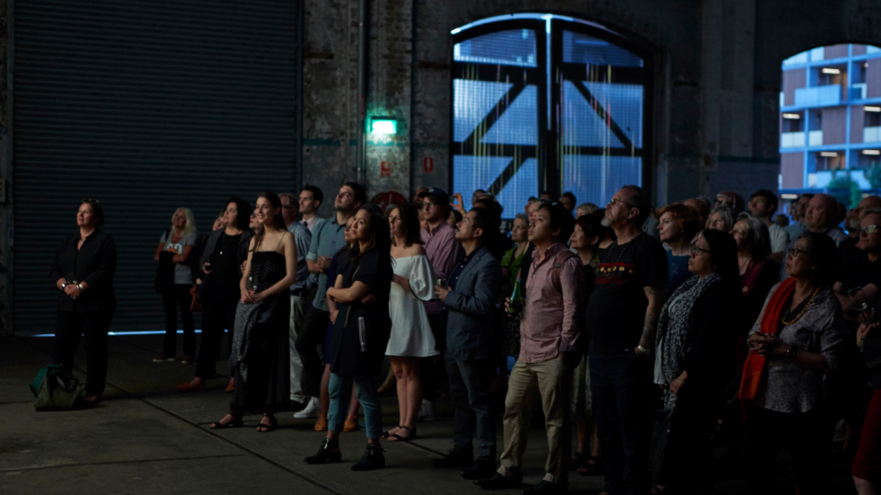 Crowd in Bay 25 at Carriageworks, listening to a speaker.