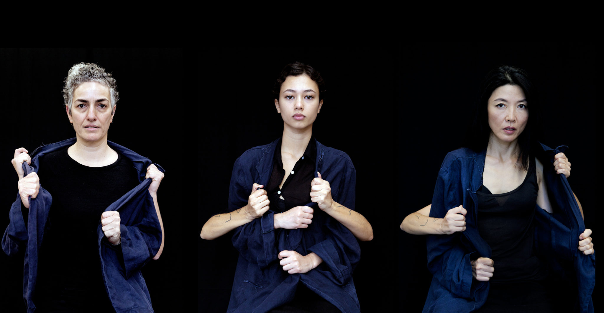 three women wearing a blue jacket that they are trying to take off whilst two hands are trying to keep it on