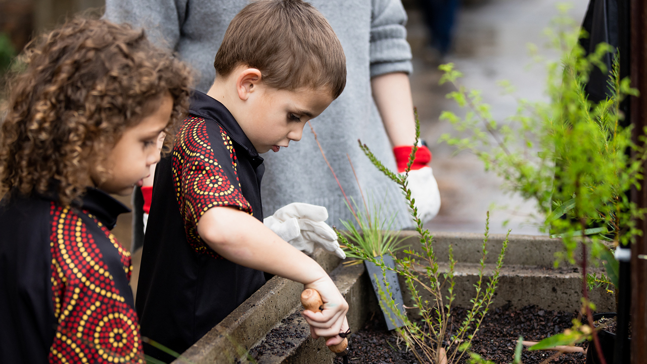 Children from Jarjum College, Redfern planting native plants in Carriageworks' First Nations Garden.