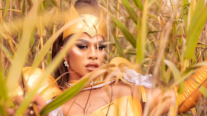 Kween Kong lies down in reeds.