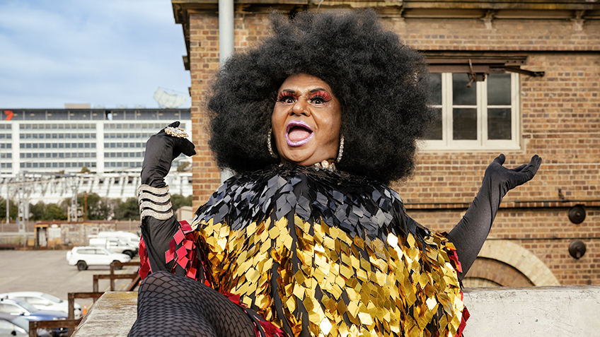 Nana Miss Koori dressed in the colours of the Aboriginal flag, in front of Carriageworks.