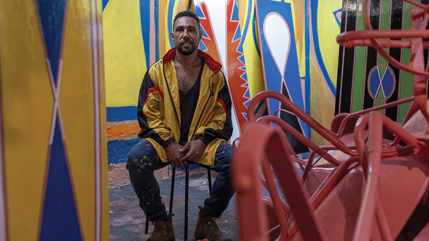 Eric Bridgeman sits among his artwork