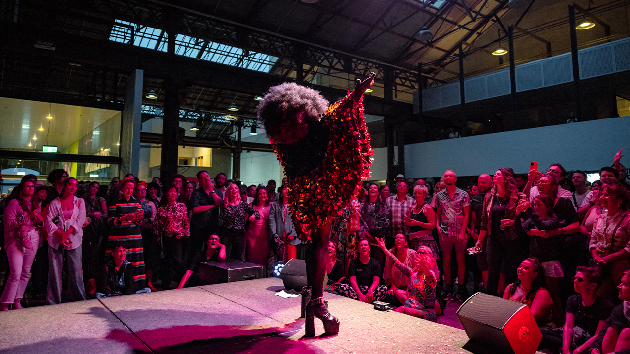 Nana Miss Koori beckons to the crowd on stage at Carriageworks.