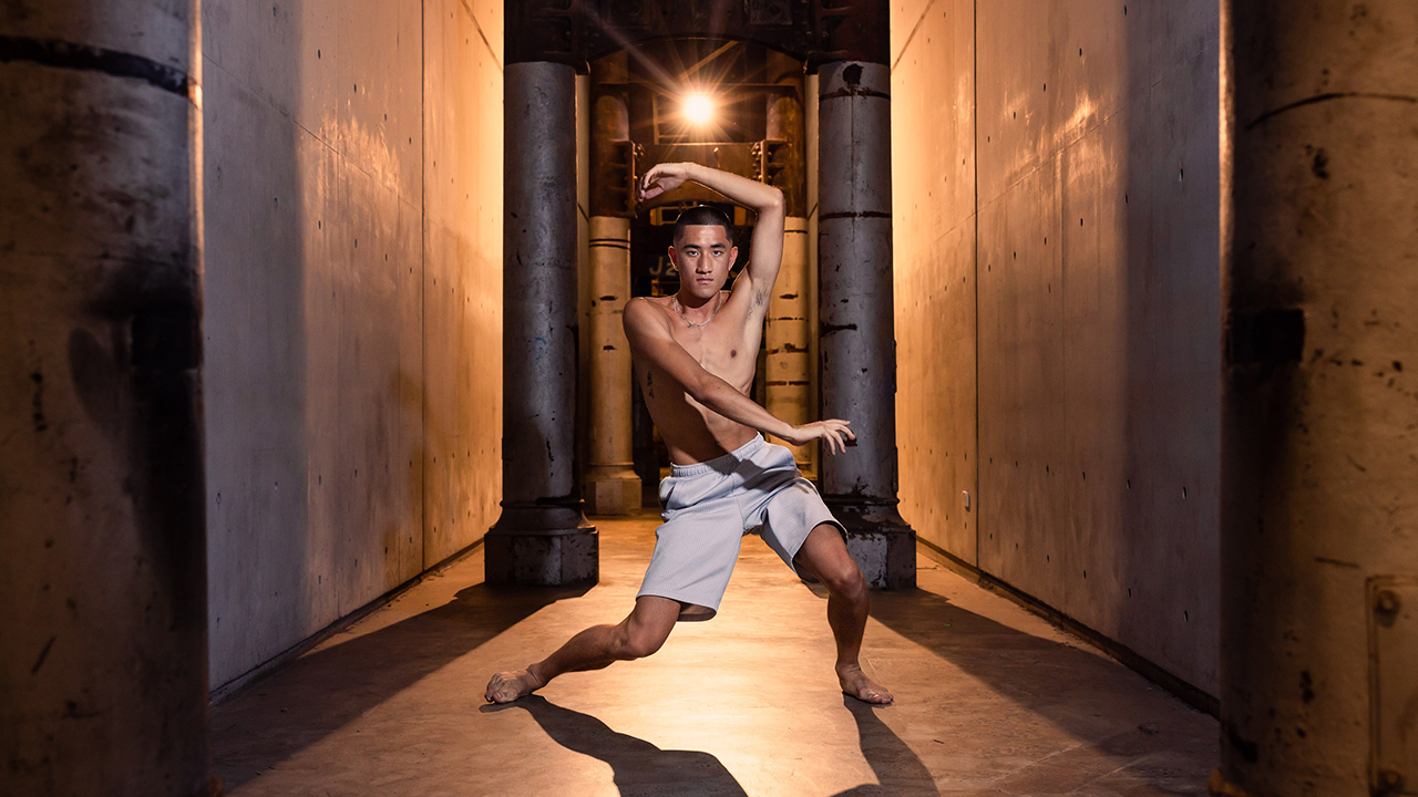 A dancer staring directly into the camera, in the Carriageworks public space.