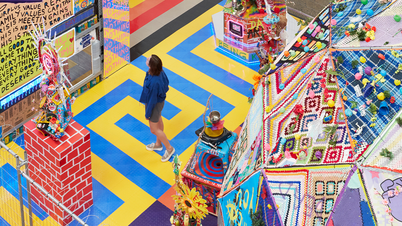 A person wanders through Paul Yore's exhibition WORD MADE FLESH