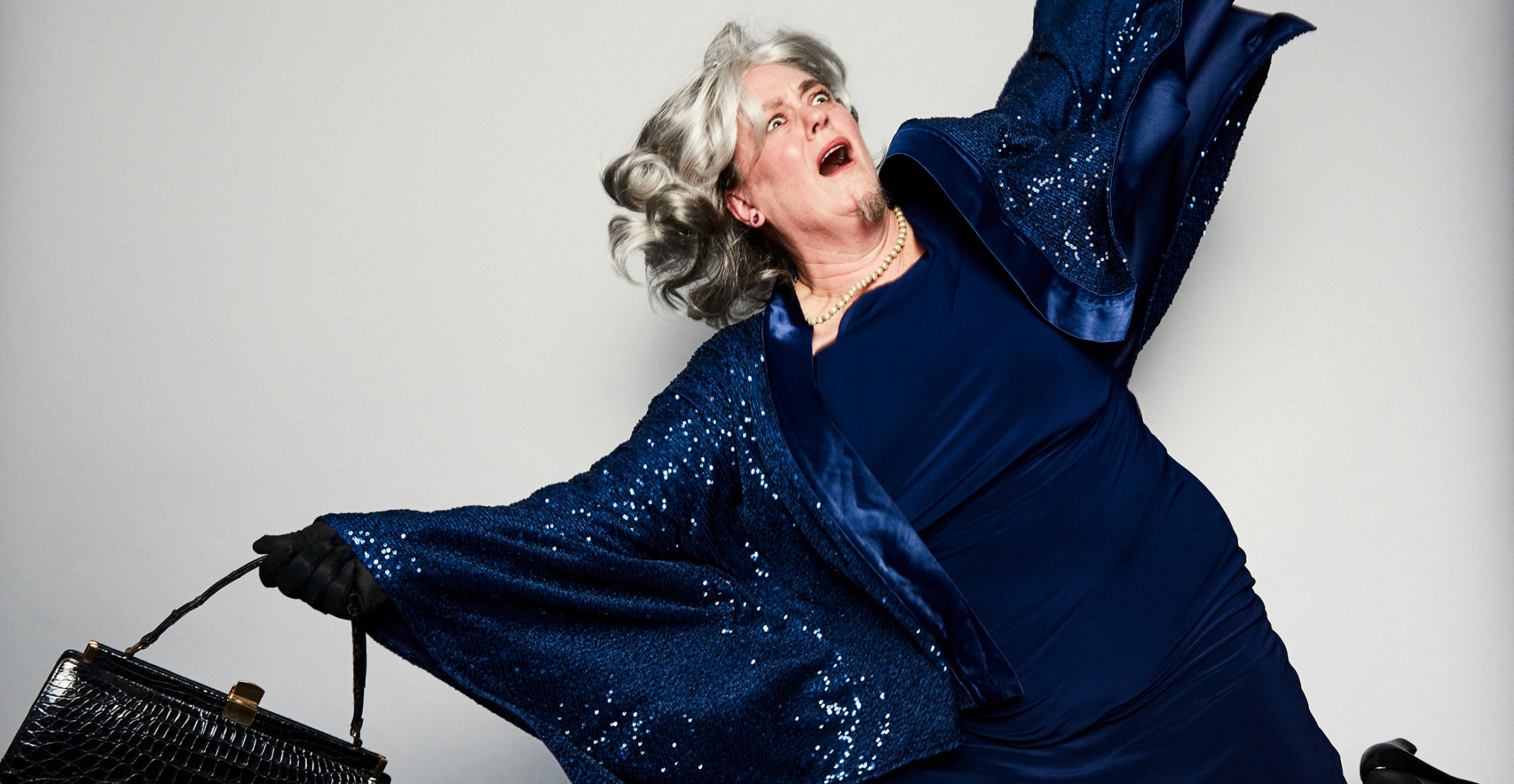 Person with grey hair and navy dress looks like they might fall